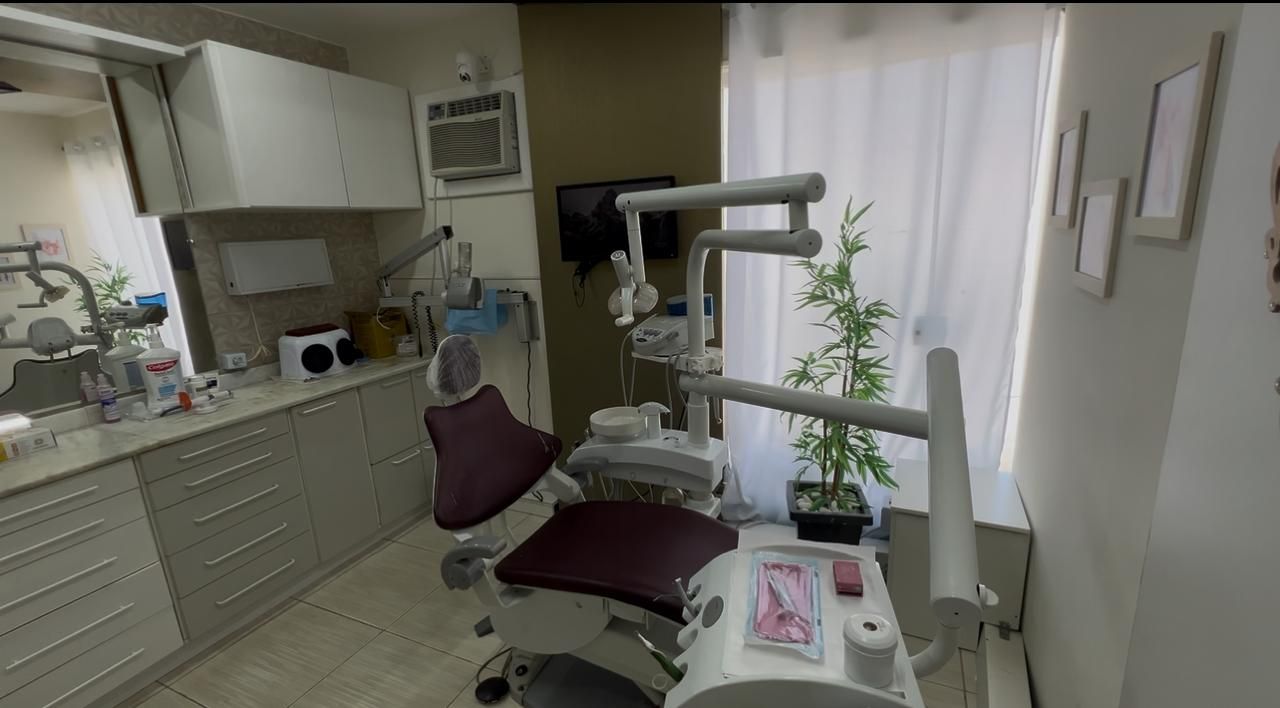 Consultório 1 visto de lado, com bancada, armários claros e janela