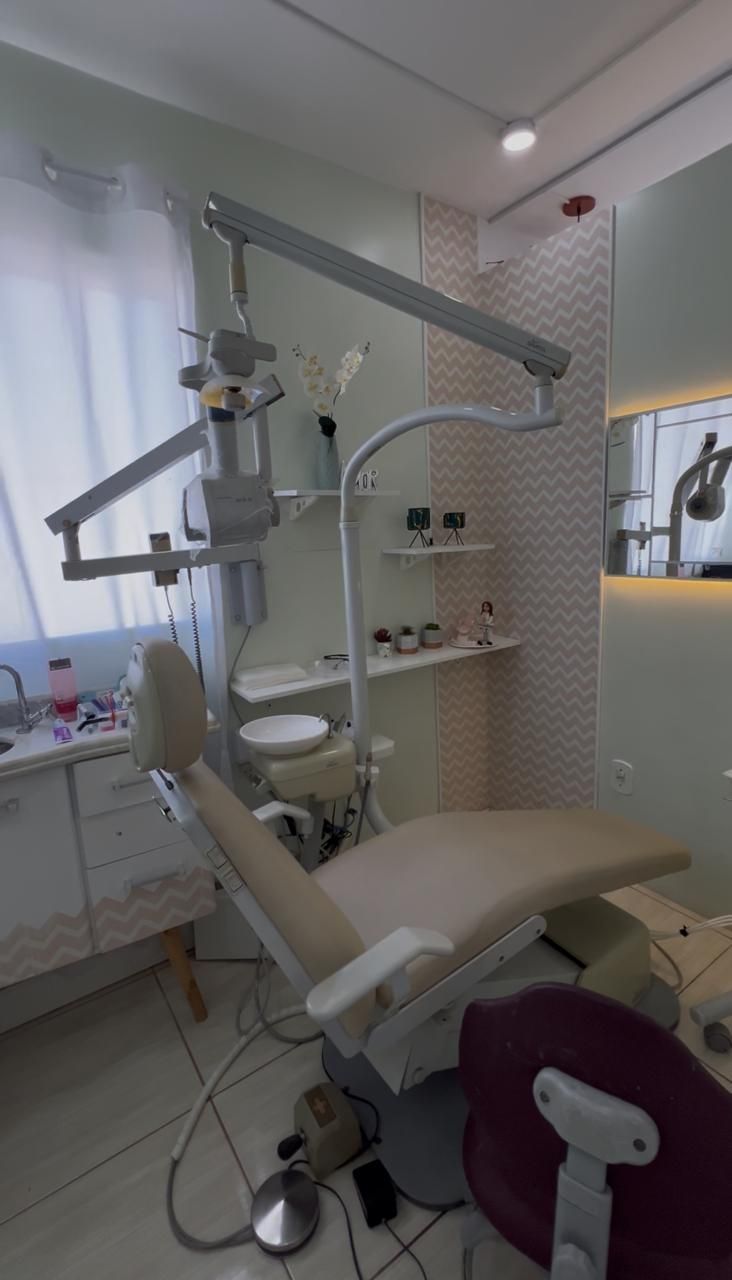 Consultório 2, com cadeira bege e parede decorada